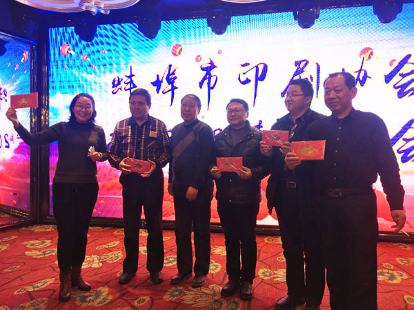 蚌埠市印刷協會副會長、蚌埠市東方彩色印刷廠總經理徐興國（中）登臺抽獎，并與獲獎人員合影留念