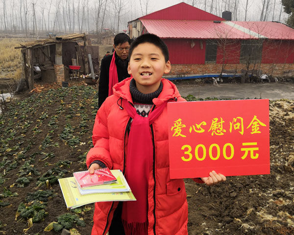 商會慰問團(tuán)小成員王睿手舉慰問金KT板和自帶的慰問寫字練習(xí)本,正懷著贈人玫瑰手留余香的感恩之心,快步走向特困戶家中